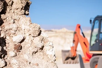 Vermessungsleistung - Erdmassenberechnung Das Bild zeigt eine Baustelle mit einem großen Erdhügel